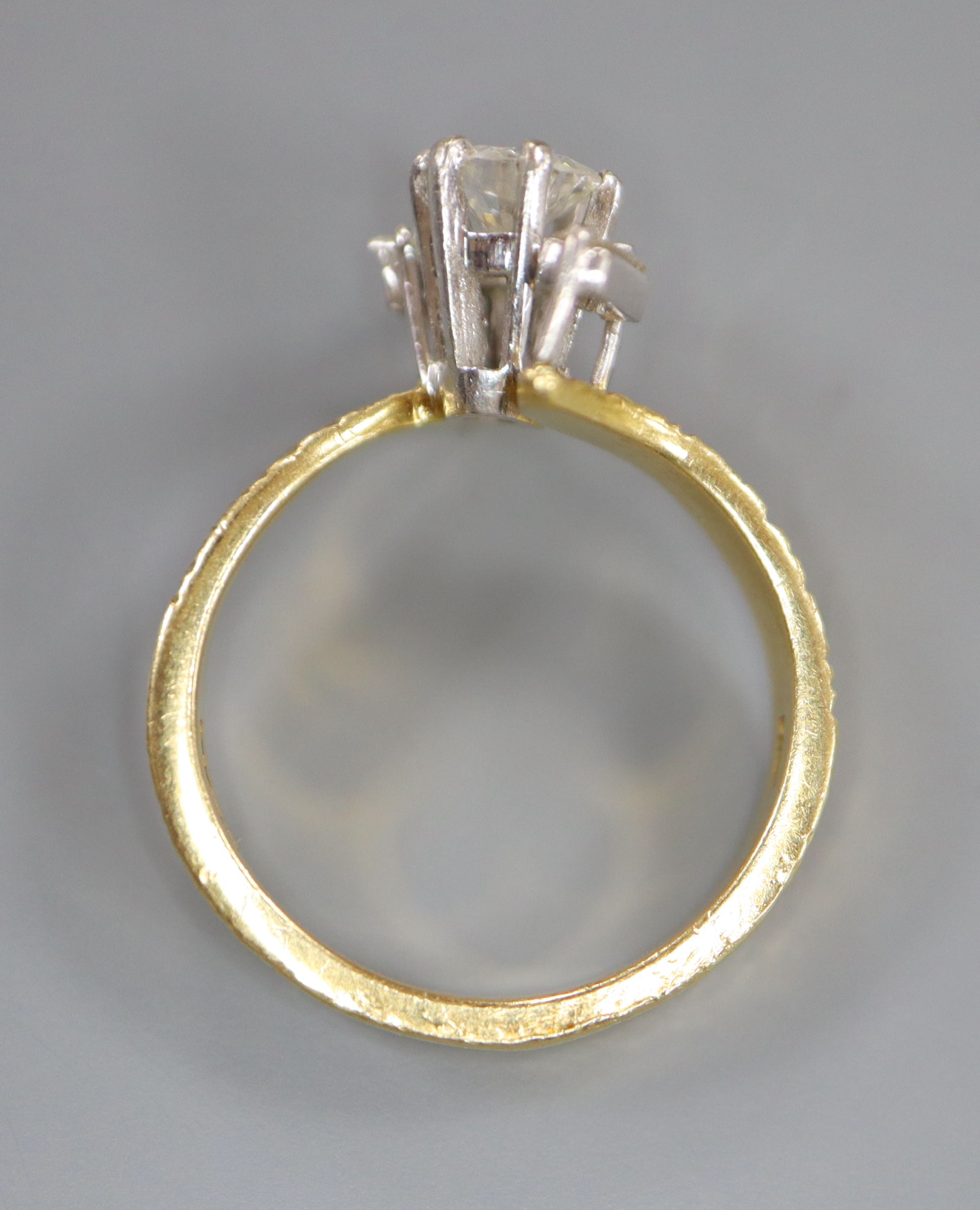 A modern textured 18ct gold and single stone diamond ring, with baguette cut diamond set shoulders,